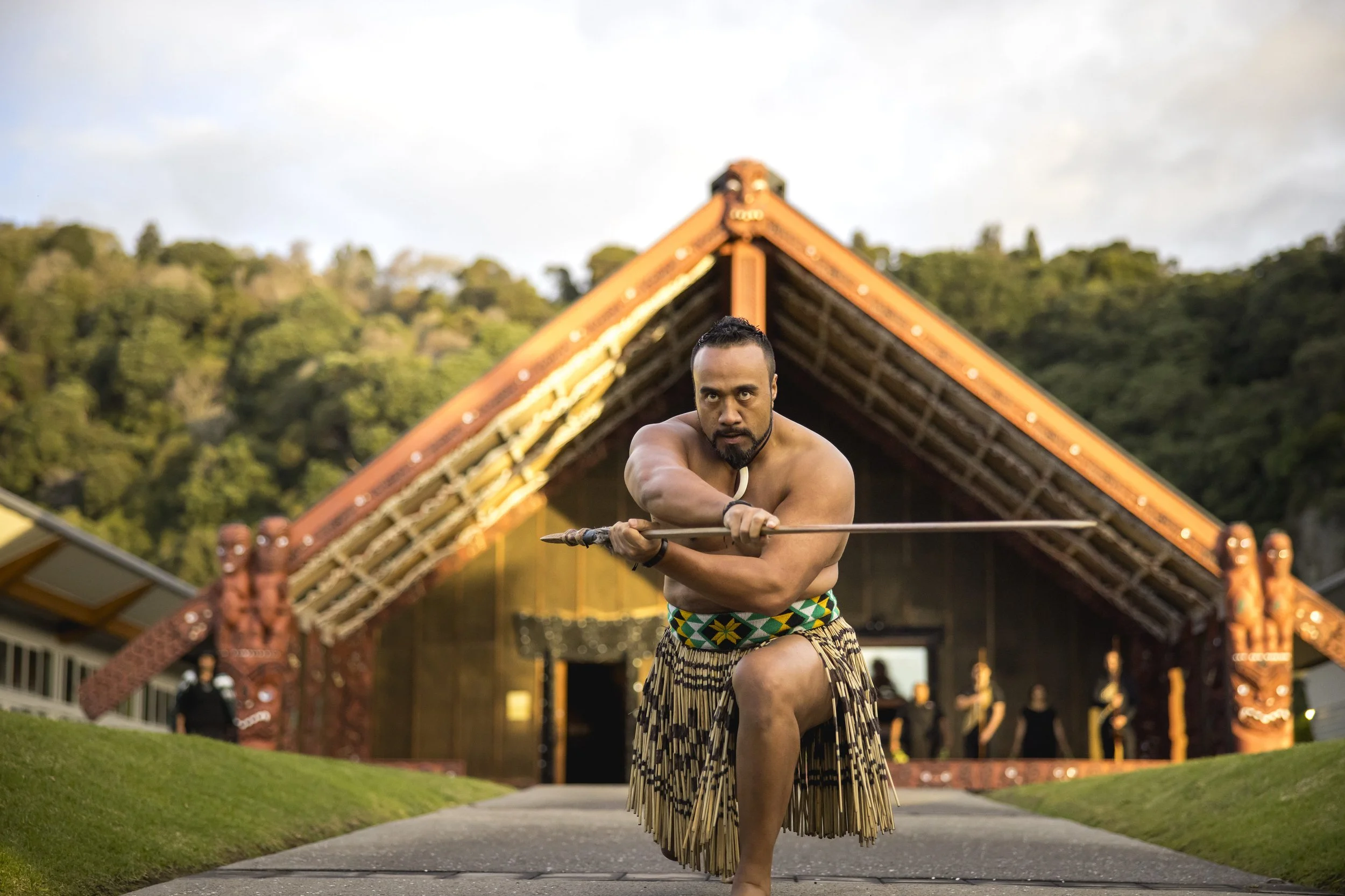 A Māori warrior performing a traditional ceremony at Mataatua, a significant meeting house, located in Whakatāne, New Zealand