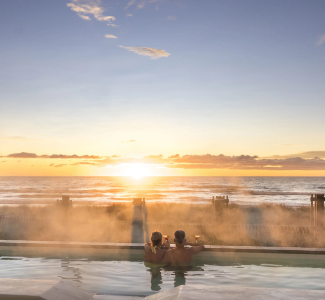 A couple enjoying the sunset while soaking in a hot spring in Christchurch, Canterbury, New Zealand.