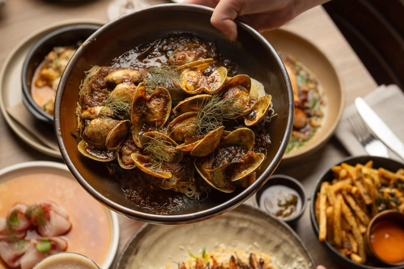 A delicious selection of dishes, including whole prawns, is displayed on a table at a modern wine bar in Melbourne, Australia.
