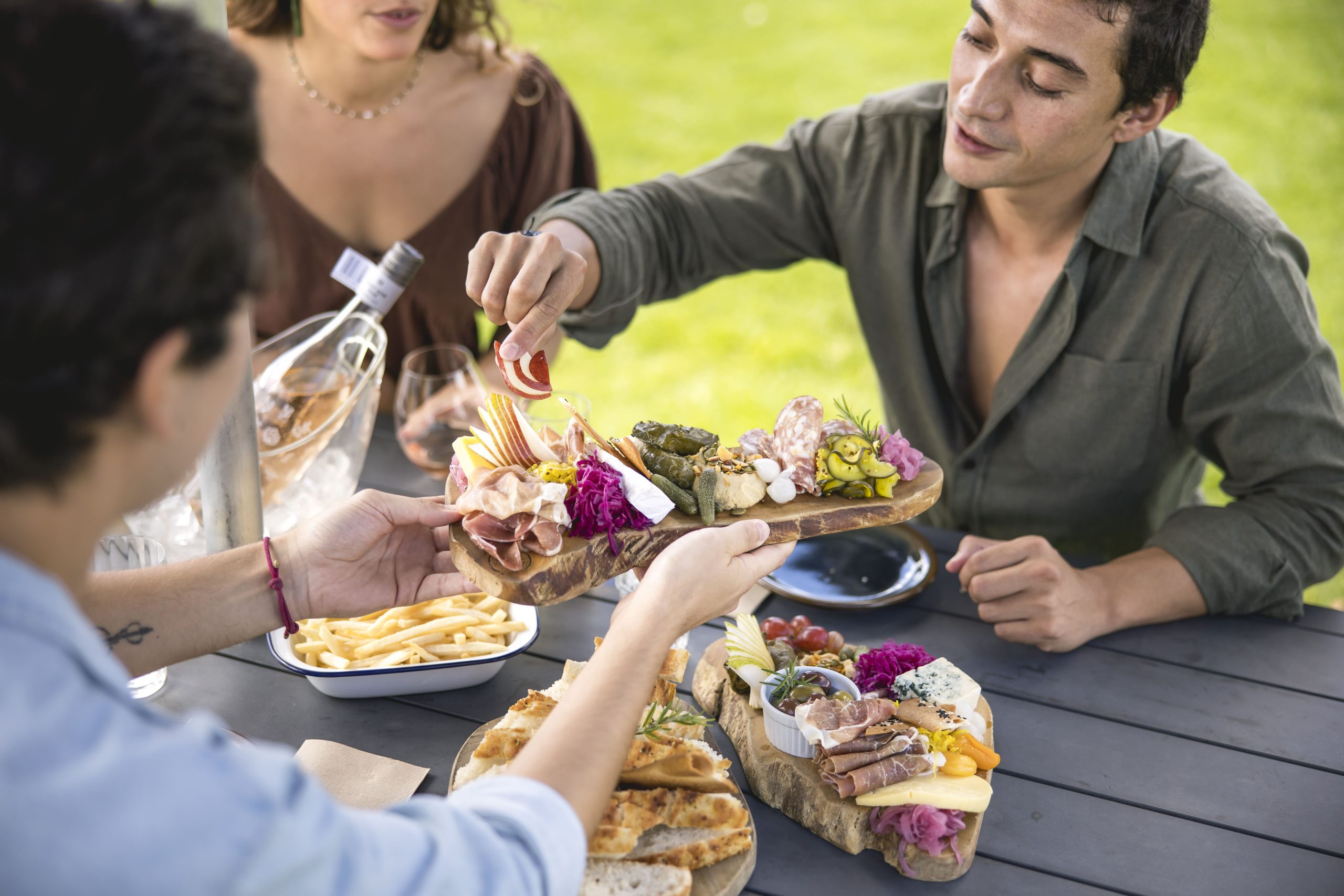 A group of friends enjoys appetizers and chilled wine during a winery tour in Auckland 