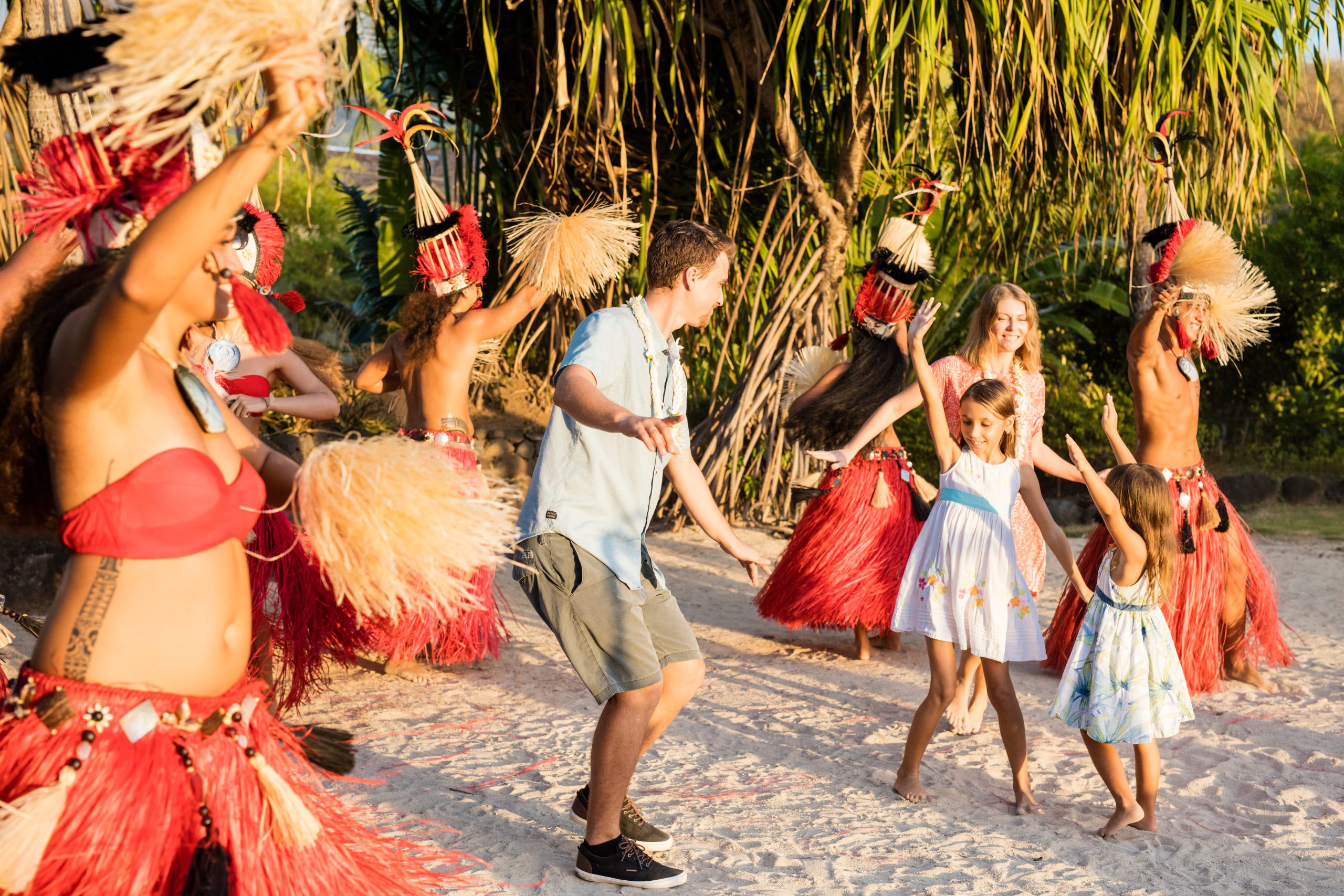Family enjoys dancing with a group of people in Tahiti