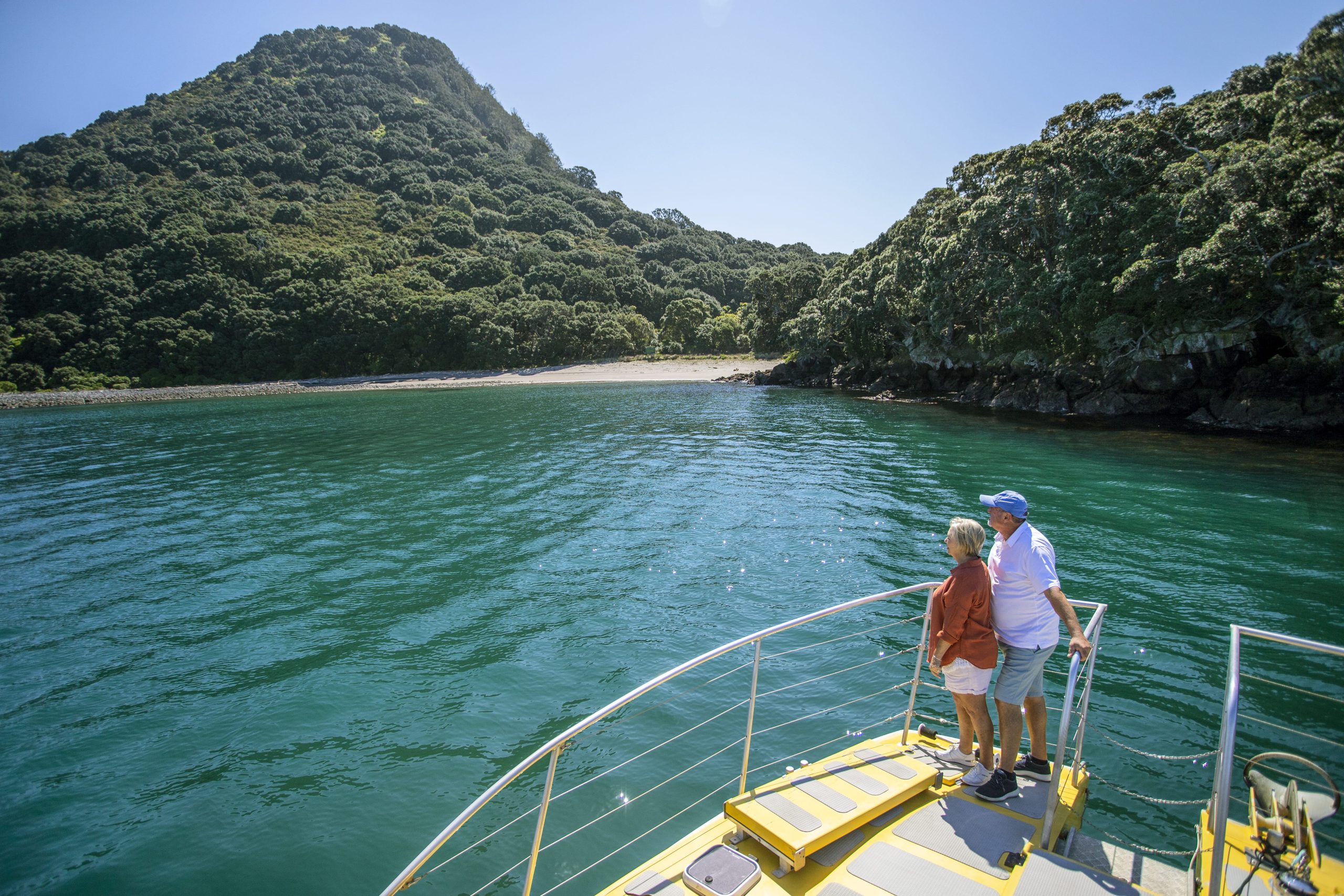 A senior couple looks over the edge of a private charter boat headed towards Moutohorā Island Bay of Plenty New Zealand.