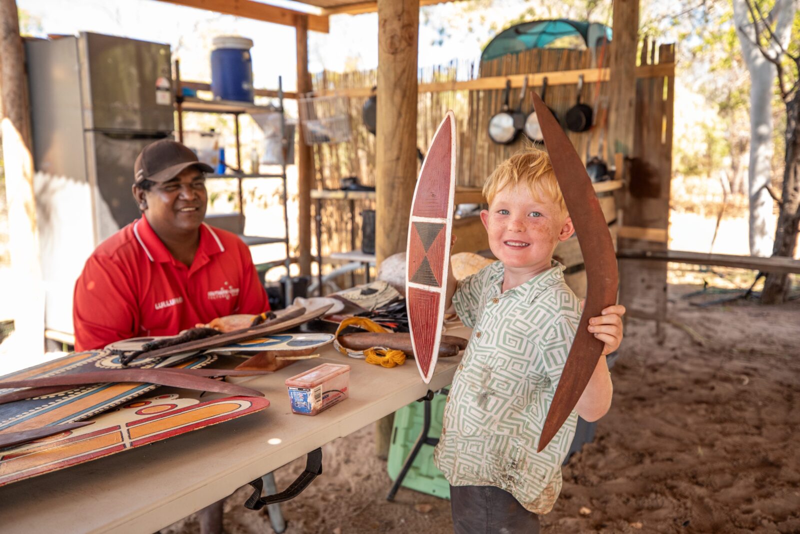 Bolo Angus showing artifacts to a young boy at Lullumb. 